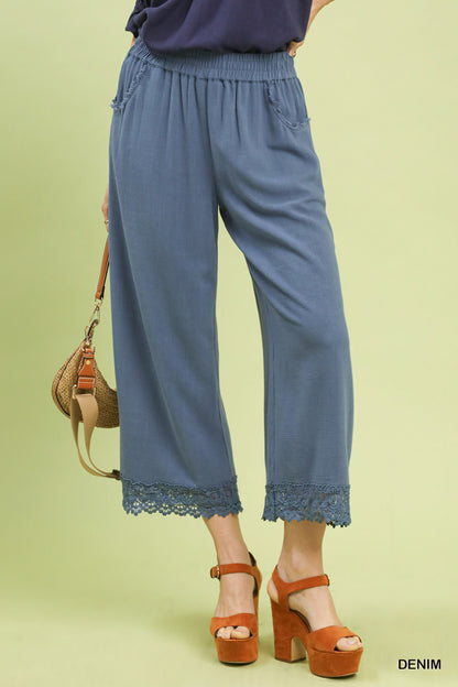 Front view of Umgee Denim Blue linen wide-leg pants with elastic waistband and lace trim, breathable linen-cotton fabric, relaxed fit.