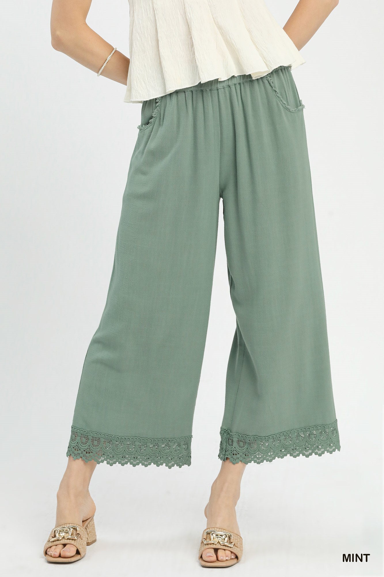 Front view of linen wide-leg pants with elastic waistband and lace trim, made from 55% linen and 45% cotton, relaxed fit.
