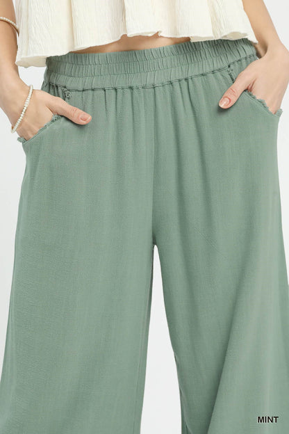 Close-up of lace trim on linen wide-leg pants, highlighting texture and delicate design, breathable linen-cotton fabric.