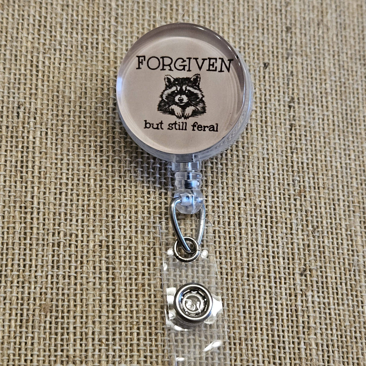 Forgiven But Still Feral Raccoon Badge Reel – Funny Retractable Nurse ID Holder, Acrylic Swivel Badge Clip for Healthcare Workers