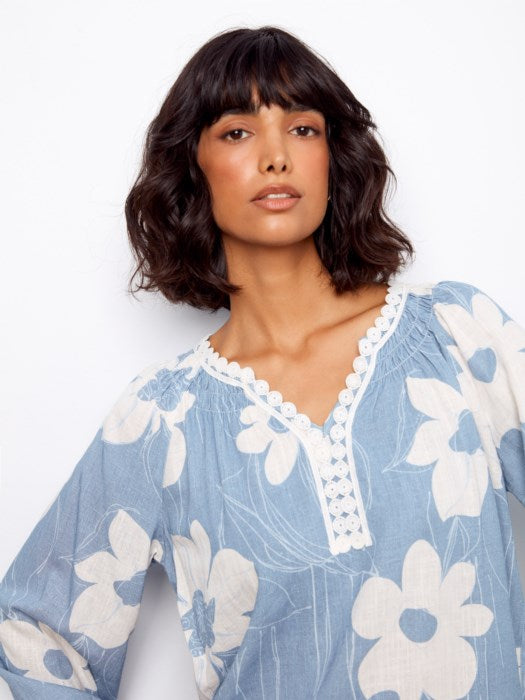 Detail shot of sleeve raglan design and crochet trim on Charlie B Waterlily blouse, ideal for vacation, casual outings, or spring events
Lifestyle image of woman wearing Charlie B Waterlily printed linen